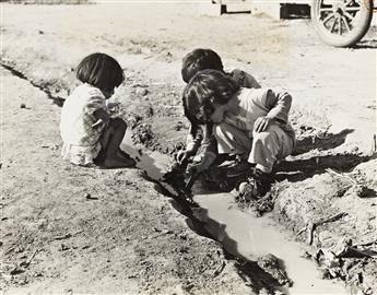 DOROTHEA LANGE (1895-1965) Mexican children playing in ditch which runs through company cotton camp near Corcoran, California.                   